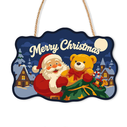 Teddy Bear Santa Village Night paint by numbers hanging sign – Santa hugging a golden teddy bear with a green toy sack, snowy village and moon, Merry Christmas, on a wooden sign with a rope hanger