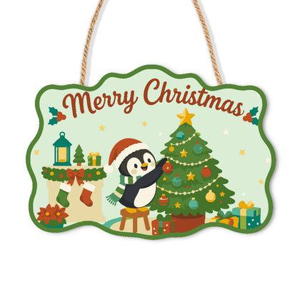 Penguin Trimming the Tree paint by numbers hanging sign – Penguin in a Santa hat standing on a stool decorating a Christmas tree beside stockings and a lantern, on a wooden sign with a rope hanger