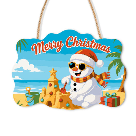 Sandcastle Snowman Christmas paint by numbers hanging sign – Snowman in a Santa hat, sunglasses and striped scarf building a sandcastle on the beach beside gifts, on a wooden sign with a rope hanger