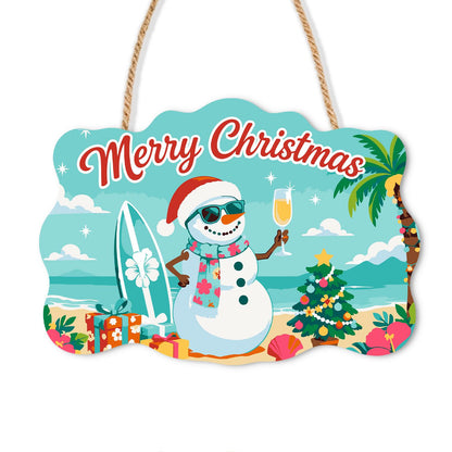 Surfboard Snowman's Bubbly Toast paint by numbers hanging sign – Snowman in a Santa hat and scarf raising champagne beside a surfboard, gifts and a small Christmas tree on the beach, on a wooden sign with a rope hanger