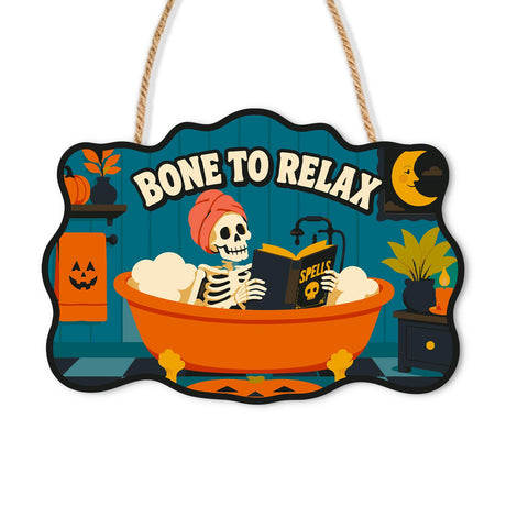Bathtub Skeleton Reading Spells paint by numbers hanging sign – Skeleton in a pink hair towel reading a Spells book in an orange bubble bath, crescent moon, Bone to Relax lettering, on a wooden sign with a rope hanger
