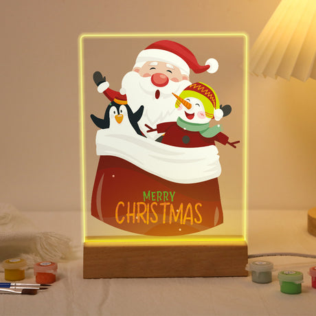 Santa's Sack of Snowy Friends paint by numbers light-up sign – Santa, a penguin and a snowman peeking out of a big red sack lettered Merry Christmas, lit up on its wooden base