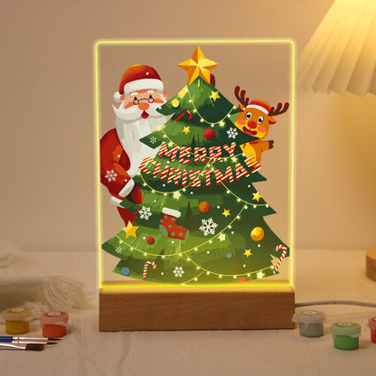 Peekaboo Santa Behind the Tree paint by numbers light-up sign – Santa and a reindeer peeking from behind a tall starry Christmas tree with lights and a Merry Christmas banner, lit up on its wooden base