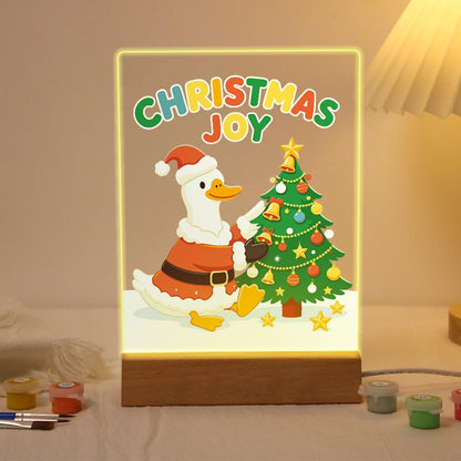 Santa Duck Trimming the Tree paint by numbers light-up sign – White duck in a Santa suit and hat hanging a bell on a decorated Christmas tree, Christmas Joy lettering above, lit up on its wooden base
