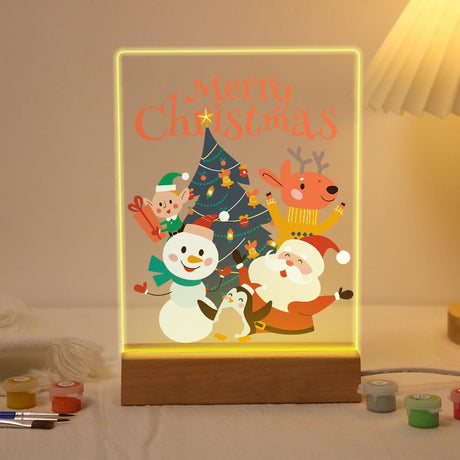 Santa's Snowman and Penguin Pals paint by numbers light-up sign – Santa, a snowman, a penguin, a reindeer and a small bear with a gift around a Christmas tree, lit up on its wooden base