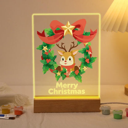Reindeer in a Star-Topped Wreath paint by numbers light-up sign – Smiling reindeer face inside a holly wreath topped with a big red bow and gold star, Merry Christmas lettering, lit up on its wooden base