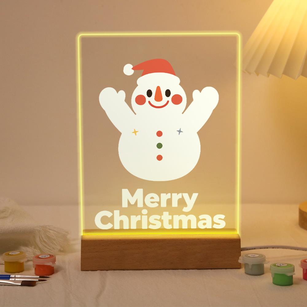 Cheering Snowman in a Red Cap paint by numbers light-up sign – Happy snowman in a red hat with both arms raised and three colored buttons, Merry Christmas lettering below, lit up on its wooden base