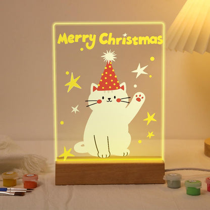 Waving Cat in a Party Hat paint by numbers light-up sign – White cat in a red polka-dot party hat waving a paw among yellow stars below Merry Christmas letters, lit up on its wooden base