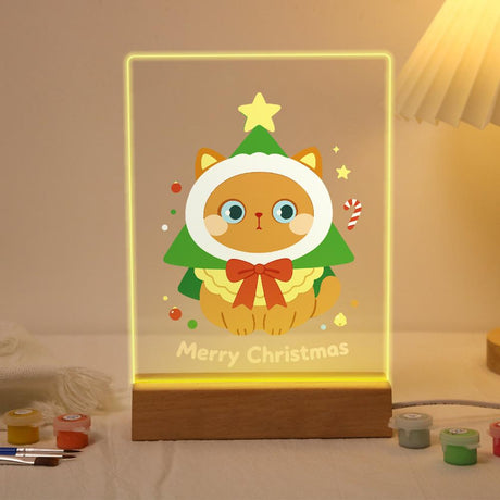 Cat in a Christmas Tree Costume paint by numbers light-up sign – Ginger cat in a green Christmas tree hood topped with a star, wearing a red bow, beside a candy cane, lit up on its wooden base