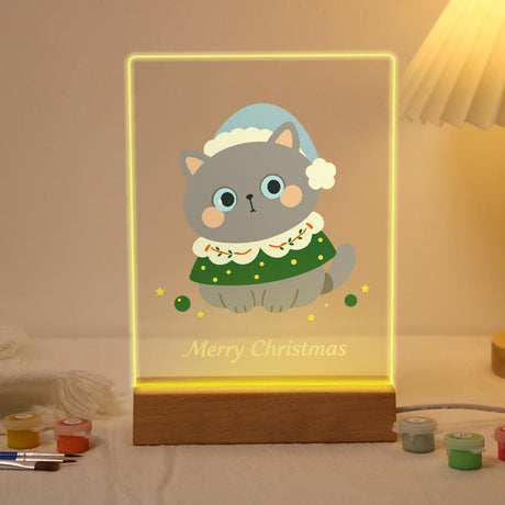 Grey Cat in a Green Capelet paint by numbers light-up sign – Grey cat in a pale blue pom-pom hat and green trimmed capelet with ornaments below, lit up on its wooden base
