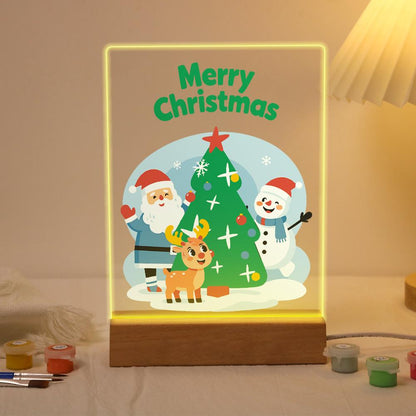 Santa, Snowman and Reindeer Trio paint by numbers light-up sign – Santa, a snowman and a reindeer gathered around a starry Christmas tree in a snowy scene, lit up on its wooden base