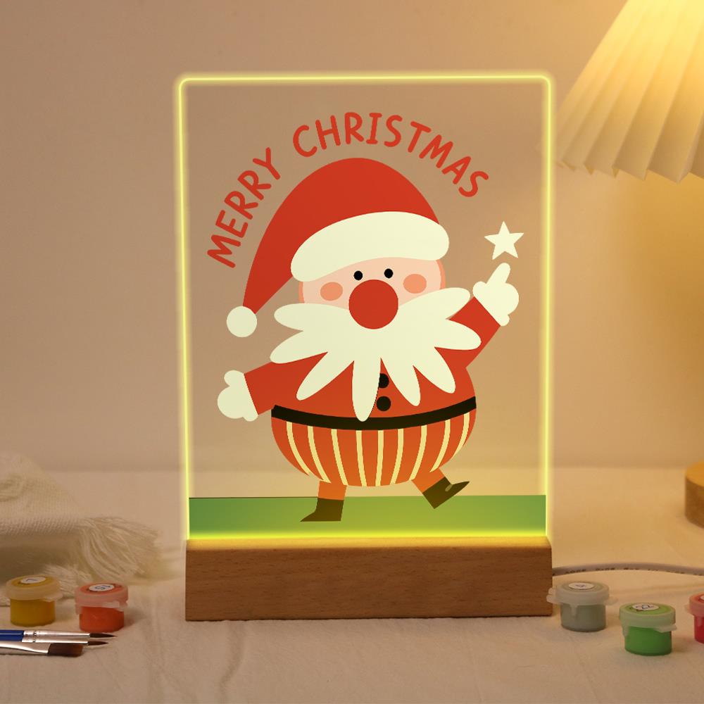 Santa Pointing to a Star paint by numbers light-up sign – Santa strolling on green grass and pointing up at a white star below arched Merry Christmas lettering, lit up on its wooden base