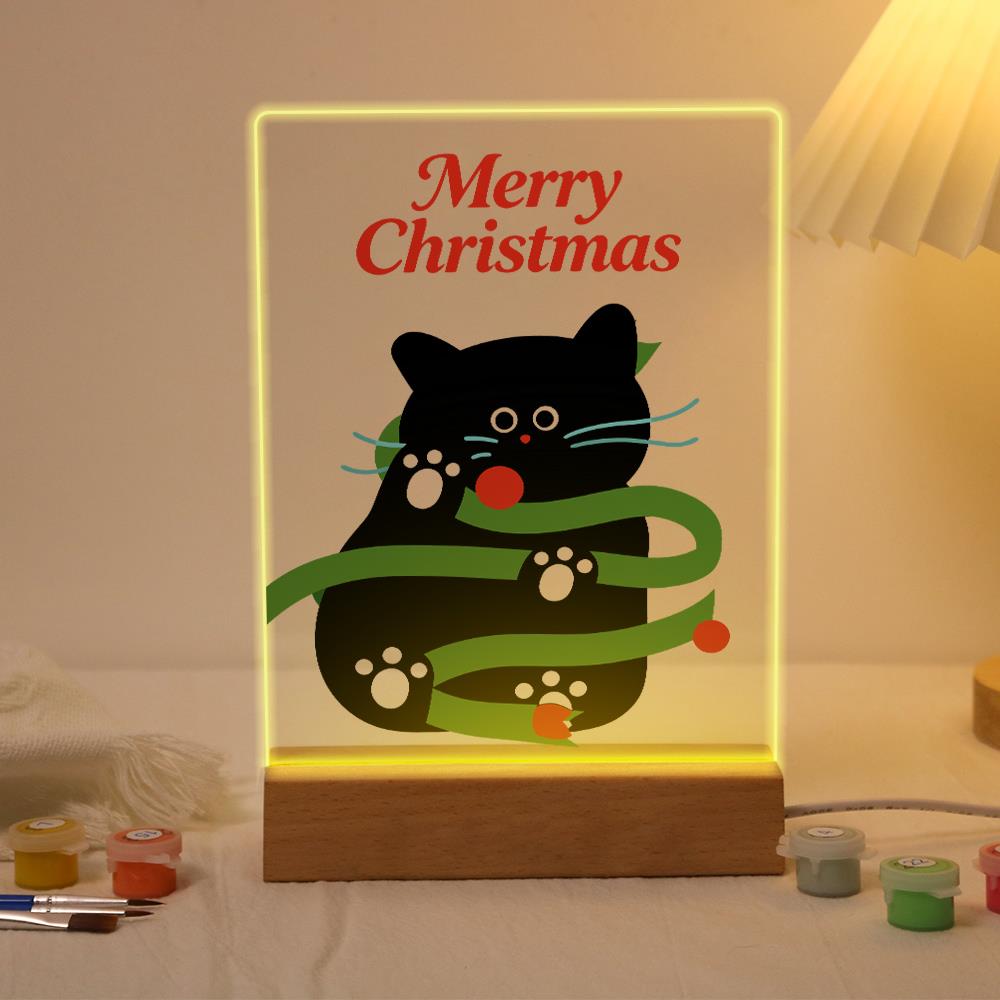 Black Cat Caught in Garland paint by numbers light-up sign – Black cat tangled in green garland with red baubles below Merry Christmas lettering, lit up on its wooden base