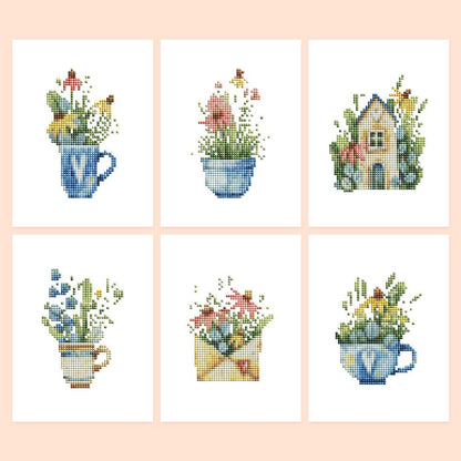 Wildflowers in Teacups mini diamond painting – Wildflowers spilling from blue teacups and a mug, an envelope full of blooms and a flower-covered cottage