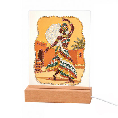 Dancer in a Bold Patterned Gown light-up pearl painting – Woman in a headwrap and bold patterned dress dancing before a golden full moon and earthen adobe walls