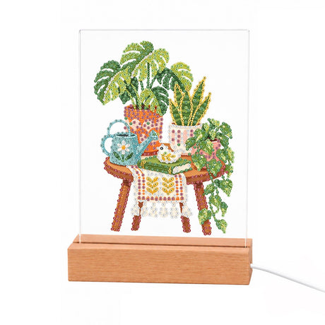 Houseplants on a Lace-Draped Stool light-up pearl painting – Monstera and snake plant in terracotta pots on a lace-draped wooden stool with a blue watering can
