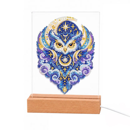 Celestial Owl in Indigo Moons light-up pearl painting – Blue and violet owl with gold eyes framed by crescent moons, stars and swirling clouds