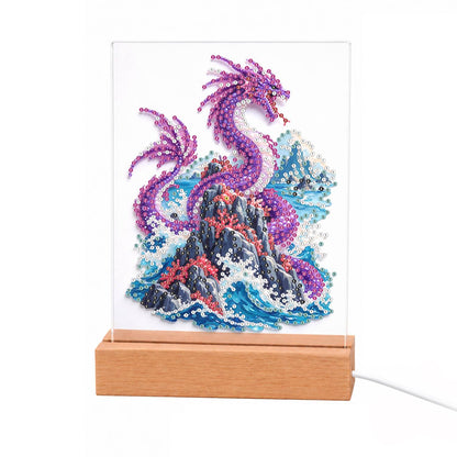 Violet Dragon Over Crashing Waves light-up pearl painting – Purple dragon coiled on a dark red-streaked rock above crashing blue waves