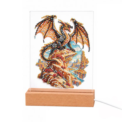 Bronze Dragon on a Cliff Top light-up pearl painting – Orange and black winged dragon perched on golden rocky cliffs above a coastal landscape