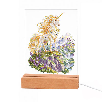 Unicorn on a Lavender Hillside light-up pearl painting – White unicorn with a flowing golden mane on a green hill of purple flowers beside a waterfall