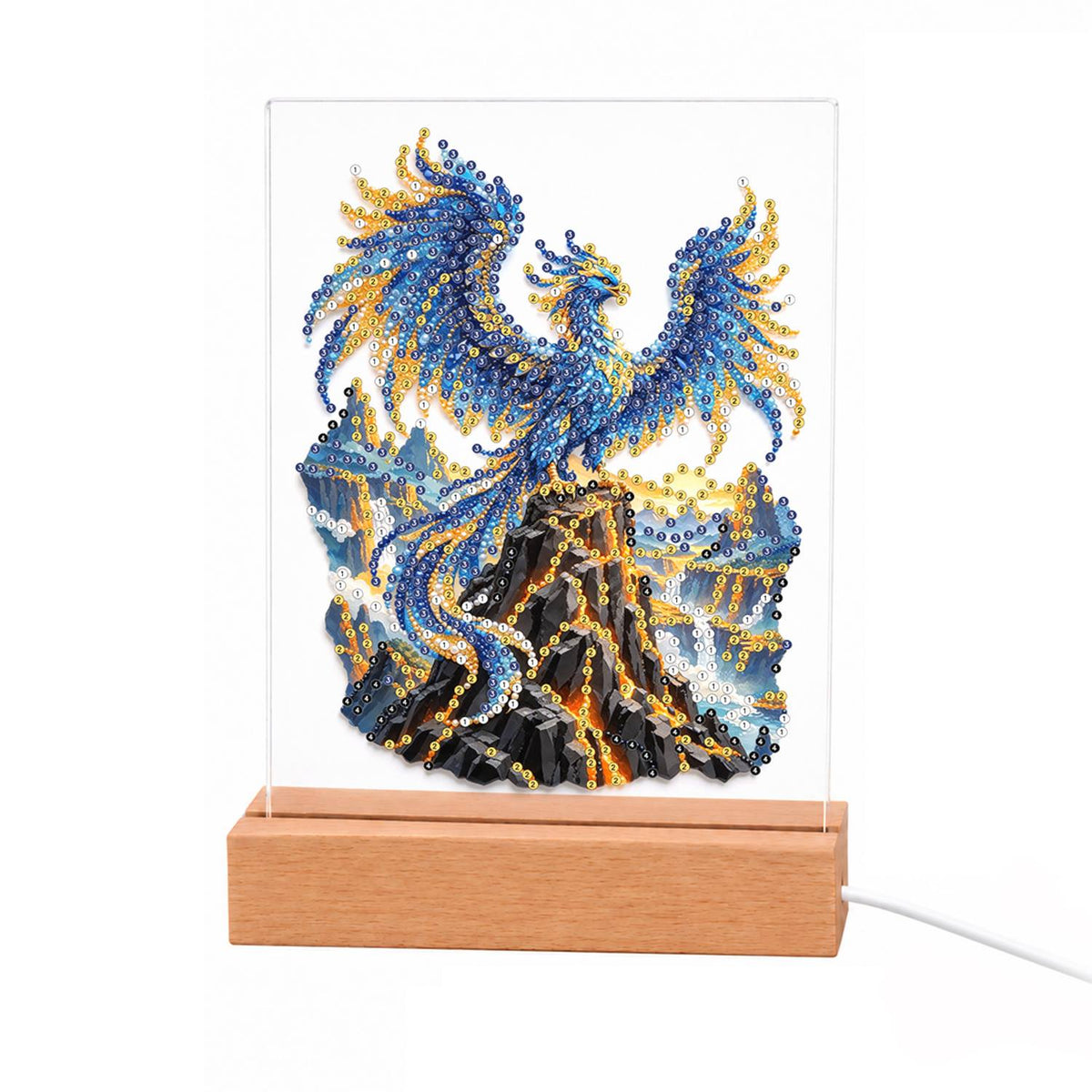 Sapphire Phoenix on a Lava Peak light-up pearl painting – Blue and gold phoenix with wings spread rising above a dark rock streaked with orange lava