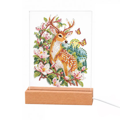 Spotted Deer in Pink Blossoms light-up pearl painting – Spotted young deer with small antlers among pink blossoms and green leaves, with orange butterflies