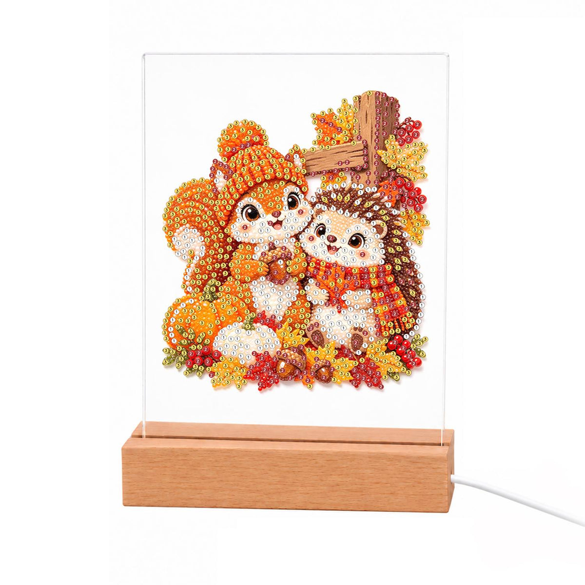 Squirrel and Hedgehog Fall Hug light-up pearl painting – Squirrel in a knit hat hugging a hedgehog in a scarf among autumn leaves, pumpkins and a wooden sign