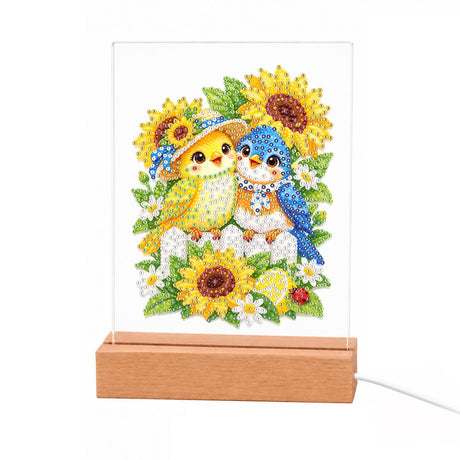 Songbird Friends in Sunflowers light-up pearl painting – Yellow and blue birds, one in a flowered hat, perched on a fence among sunflowers