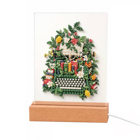 Ivy-Wrapped Vintage Typewriter light-up pearl painting – Vintage typewriter overgrown with green leaves and white flowers, with small stacks of books