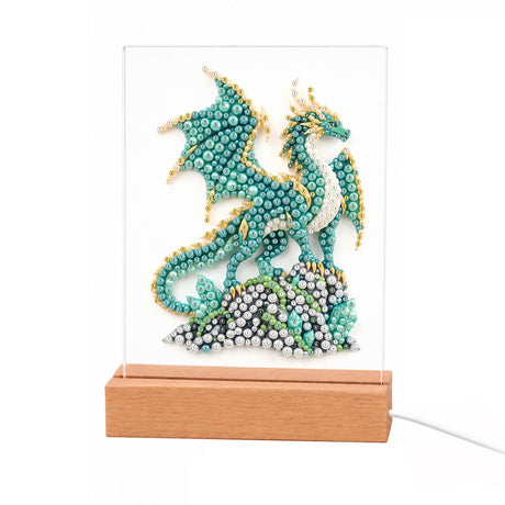 Jade Dragon Perched on a Rock light-up pearl painting – Teal dragon with gold-edged wings perched on a mound of gray and green stones
