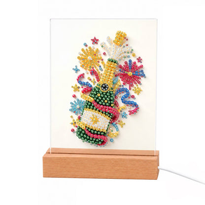 Popping Bubbly and Fireworks light-up pearl painting – Green bottle of sparkling wine popping its cork amid fireworks, confetti and curling streamers