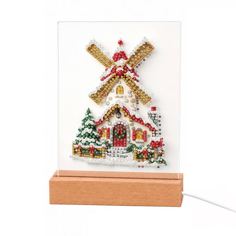 Snowy Windmill with Golden Sails light-up pearl painting – Snowy windmill with golden sails above a red-trimmed cottage, decorated for Christmas beside a fir tree
