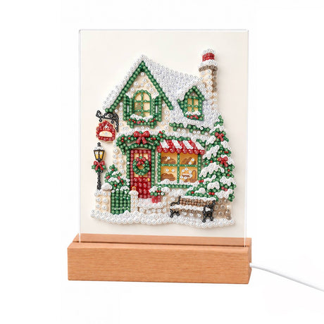 Snowy Cottage with a Garden Bench light-up pearl painting – Snow-covered white cottage with green window frames, a wreathed red door, lamppost and garden bench