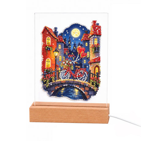 Red Bicycle on a Moonlit Bridge light-up pearl painting – Red bicycle with heart balloons on a stone bridge over a canal between lamplit houses under a full moon