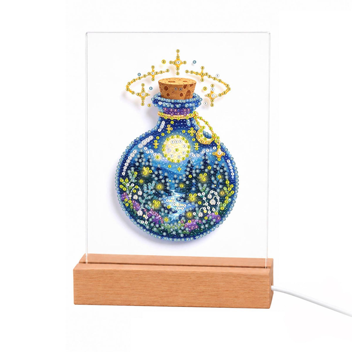 Starry Night in a Potion Bottle light-up pearl painting – Round corked blue bottle holding a starry sky, crescent moon and tiny flowers, crowned with gold sparkles