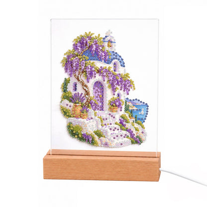 Whitewashed Steps Under Wisteria light-up pearl painting – White island house with blue accents draped in purple wisteria, with stone steps leading down to the sea