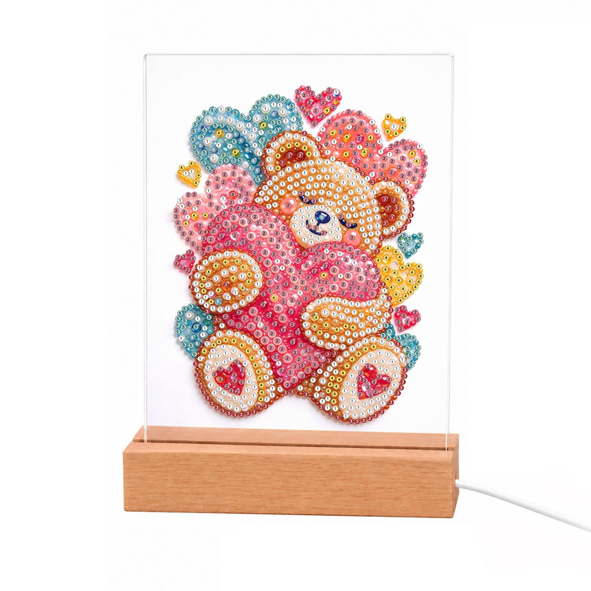 Teddy Bear Hugging a Pink Heart light-up pearl painting – Pink teddy bear hugging a large pink heart, surrounded by small pink, blue and gold hearts