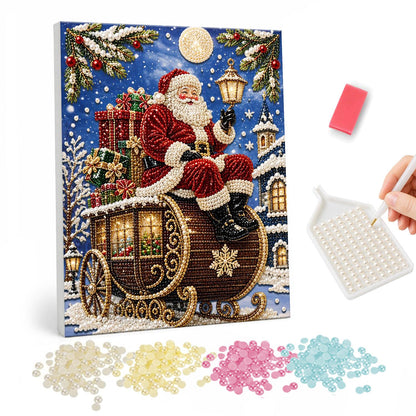 Santa on a Golden Carriage pearl painting – Santa seated atop an ornate gold carriage loaded with gifts on a snowy night with a full moon and lamp