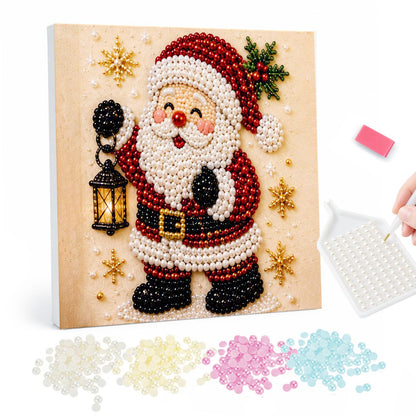 Santa Lighting the Way pearl painting – Cartoon Santa waving and holding up a glowing lantern, with holly and gold stars on cream
