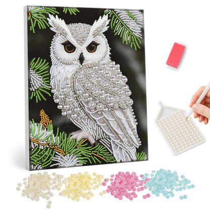Snowy Owl on Pine Branch pearl painting – White snowy owl with amber eyes perched on a pine branch