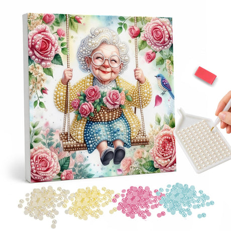 Swinging Granny in Pink Roses pearl painting – Smiling grandmother in glasses on a rope swing holding roses, surrounded by pink roses and a bluebird