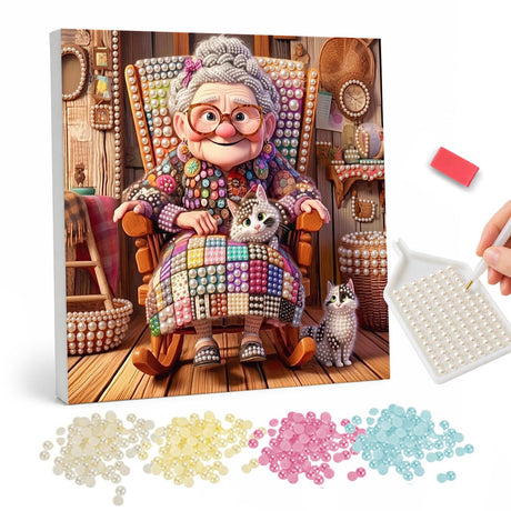 Granny's Patchwork Rocking Chair pearl painting – Smiling grandmother in glasses in a rocking chair under a patchwork quilt with two cats
