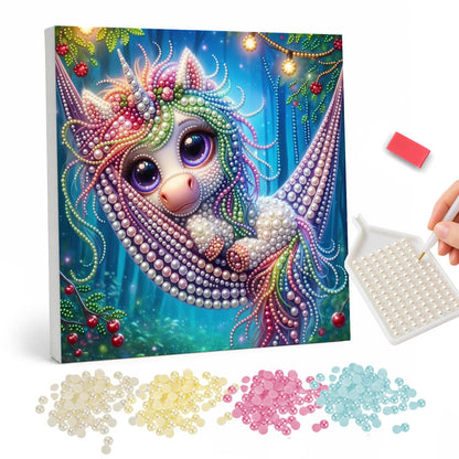 Unicorn Napping in a Hammock pearl painting – Big-eyed baby unicorn with a flower crown relaxing in a hammock in a fairy-lit forest