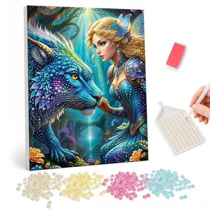 Fairy Maiden and Sapphire Dragon pearl painting – Golden-haired fairy in blue reaching toward a scaly blue dragon in a glowing teal forest