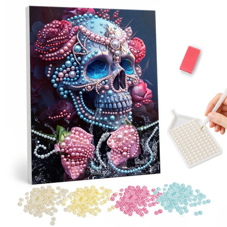 Strawberry and Rose Jewel Skull pearl painting – Skull encrusted with blue and pink beads, topped with pink roses, with two pink strawberries below