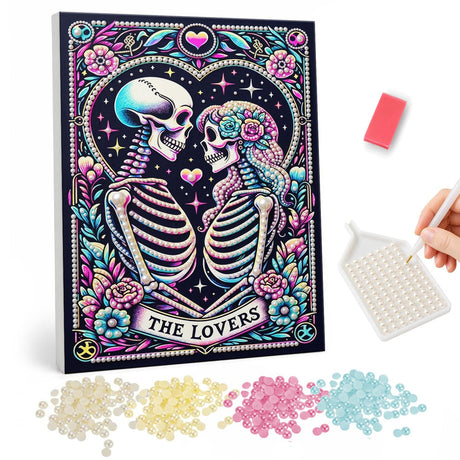 Skeleton Lovers in a Pink Heart pearl painting – Two skeletons sharing a kiss inside a heart on a black tarot-style card trimmed with pink flowers