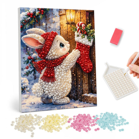 Bunny Reaching for a Stocking pearl painting – White bunny in a red hat and scarf reaching up to a stocking hung on a wooden door by lantern light