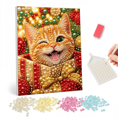 Winking Kitten in a Gift Box pearl painting – Winking ginger kitten popping out of a red gift box tied with a gold bow