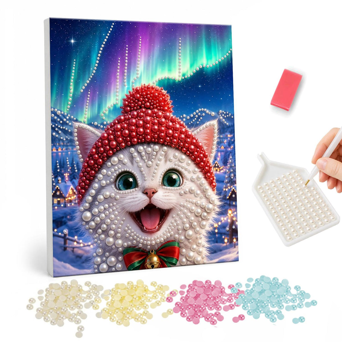 Northern Lights White Kitten pearl painting – White kitten in a red knit bobble hat and jingle bell bow under northern lights in a snowy village