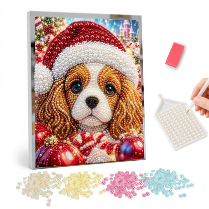 Santa-Hat Spaniel and Candy Cane pearl painting – Spaniel puppy in a Santa hat with a candy cane and red baubles before a pink candy castle